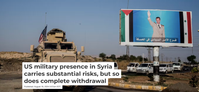 A U.S. military vehicle drives past a poster showing Syrian President Bashar al-Assad. AP Photo/Baderkhan Ahmad, File